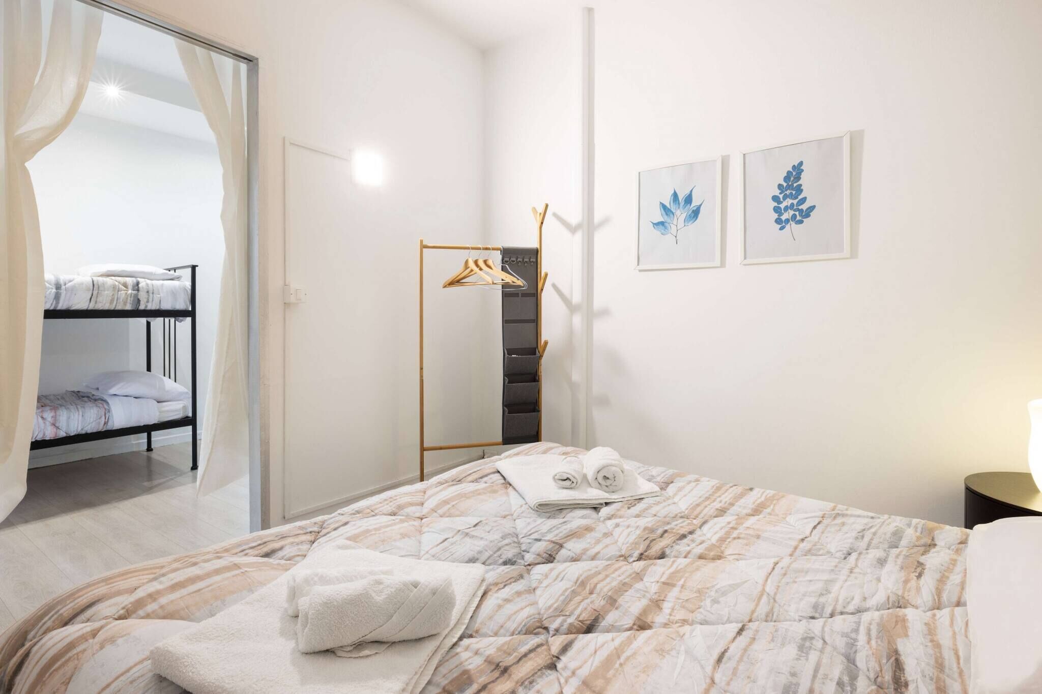 A bedroom with a bed, a wardrobe, and a mirror.