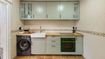 Een compacte keuken met een wasmachine, vaatwasser en een klein oven.