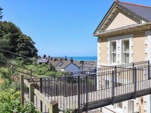 A coastal residential area with a view of the sea, a wooden staircase, and a building with a beige facade. - Sea Vista (Bideford)