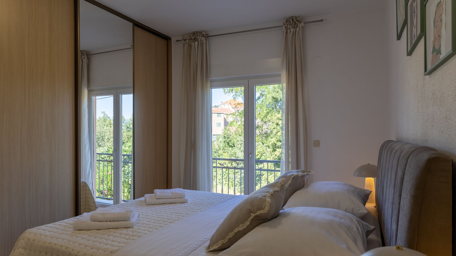 Une chambre à coucher avec un lit, des rideaux, une fenêtre et un balcon.