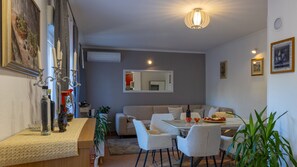 A modern living room with a dining area, a sofa, a coffee table, and a chandelier. - Villa Emanuela by Villas Guide (Grubine)