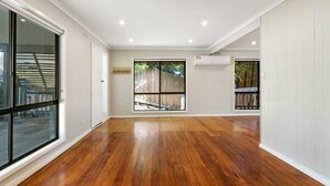 A spacious room with hardwood flooring, large windows, and an air conditioning unit. - HAVELI...... (Metung)