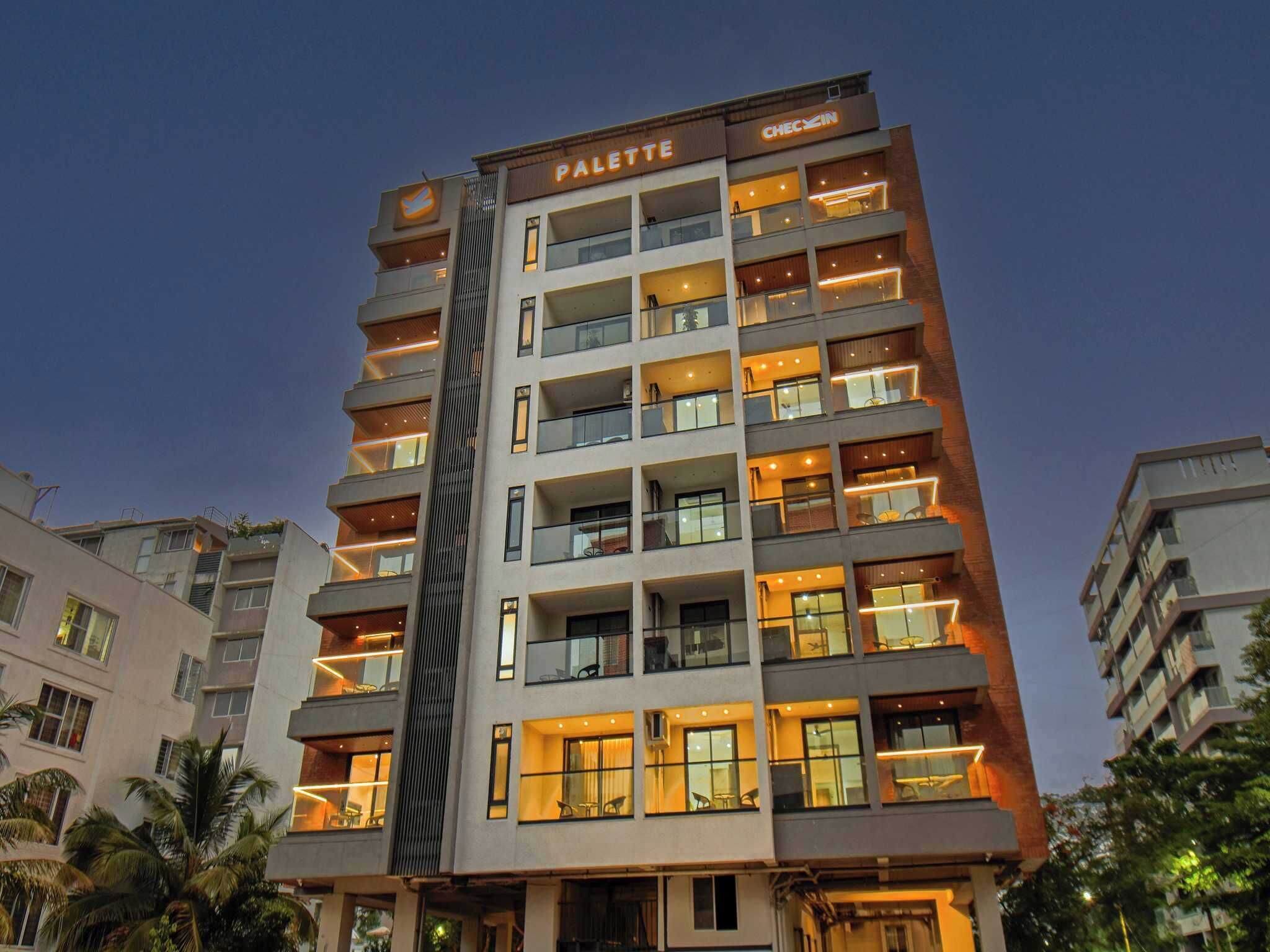 A multi-story hotel with balconies, a visible sign reading 'PALETTE,' and a 'CHECIN' sign on the top right.