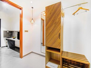 Una cocina moderna con un lavaplatos integrado, una lámpara colgante y un armario de madera con espejo.