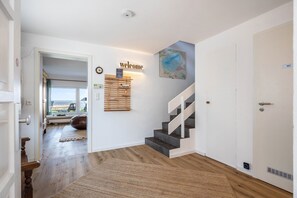 A staircase with a 'welcome' sign, a map, and a 'WC' sign. - Panoramic Lake House at Steinhuder Meer – Your Exclusive Retreat by the Water (Wunstorf)