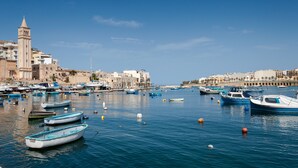 Un port avec des bateaux, une tour et des bâtiments le long de la rive.