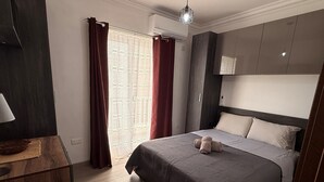 Une chambre d’hôtel moderne équipée d’un lit, d’un bureau et d’une armoire.