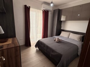 Ein modernes Hotelzimmer mit Bett, Schreibtisch und Kleiderschrank.
