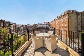 A rooftop terrace with a round table and wicker chairs, surrounded by a metal railing. - 6 Mins Walk to Selfridges, Marble Arch Penthouse (Greater London)
