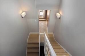 A staircase with wooden steps and white railings, leading to a room with a herringbone floor pattern. - 6 Mins Walk to Selfridges, Marble Arch Penthouse (Greater London)