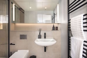 A modern bathroom with a white sink, a mirror, and a towel rack. - 9 Mins Walk to Selfridges, Marble Arch Studio (Greater London)