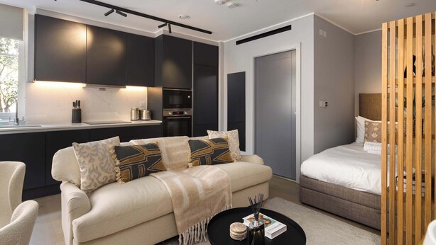 A modern living space with a sofa, a coffee table, a bed, and a kitchen area. - 9 Mins Walk to Selfridges, Marble Arch Studio (Greater London)