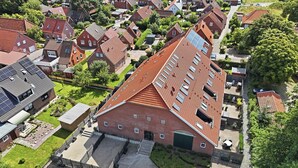 Ein Wohngebiet mit mehreren Häusern, einer gepflasterten Auffahrt und einem großen Gebäude mit rotem Dach.