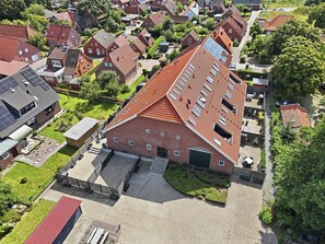 Ein Wohngebiet mit mehreren Häusern, einer gepflasterten Auffahrt und einem großen Gebäude mit rotem Dach.