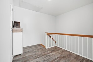 A room with a white wall, a wooden floor, and a white railing with a wooden top. - To the Ankerplatz: A vacation near Greetsiel with a large terrace (Greetsiel)
