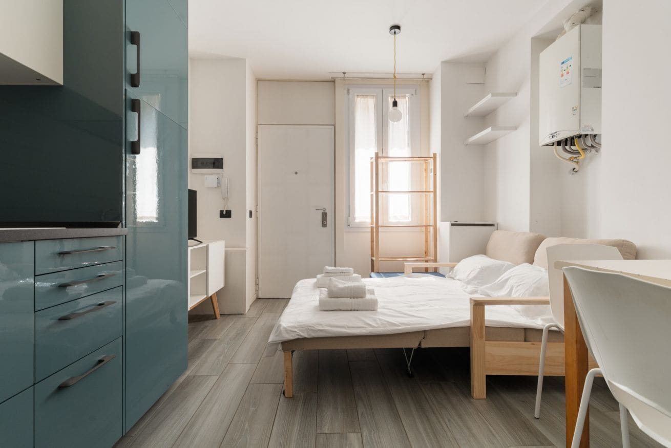 Une chambre moderne avec un lit, un bureau, une armoire et une fenêtre.