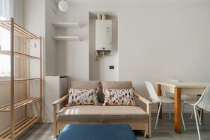 Habitació moderna amb un sofà, una taula de dinar, una panxa i un calefactor integrat.