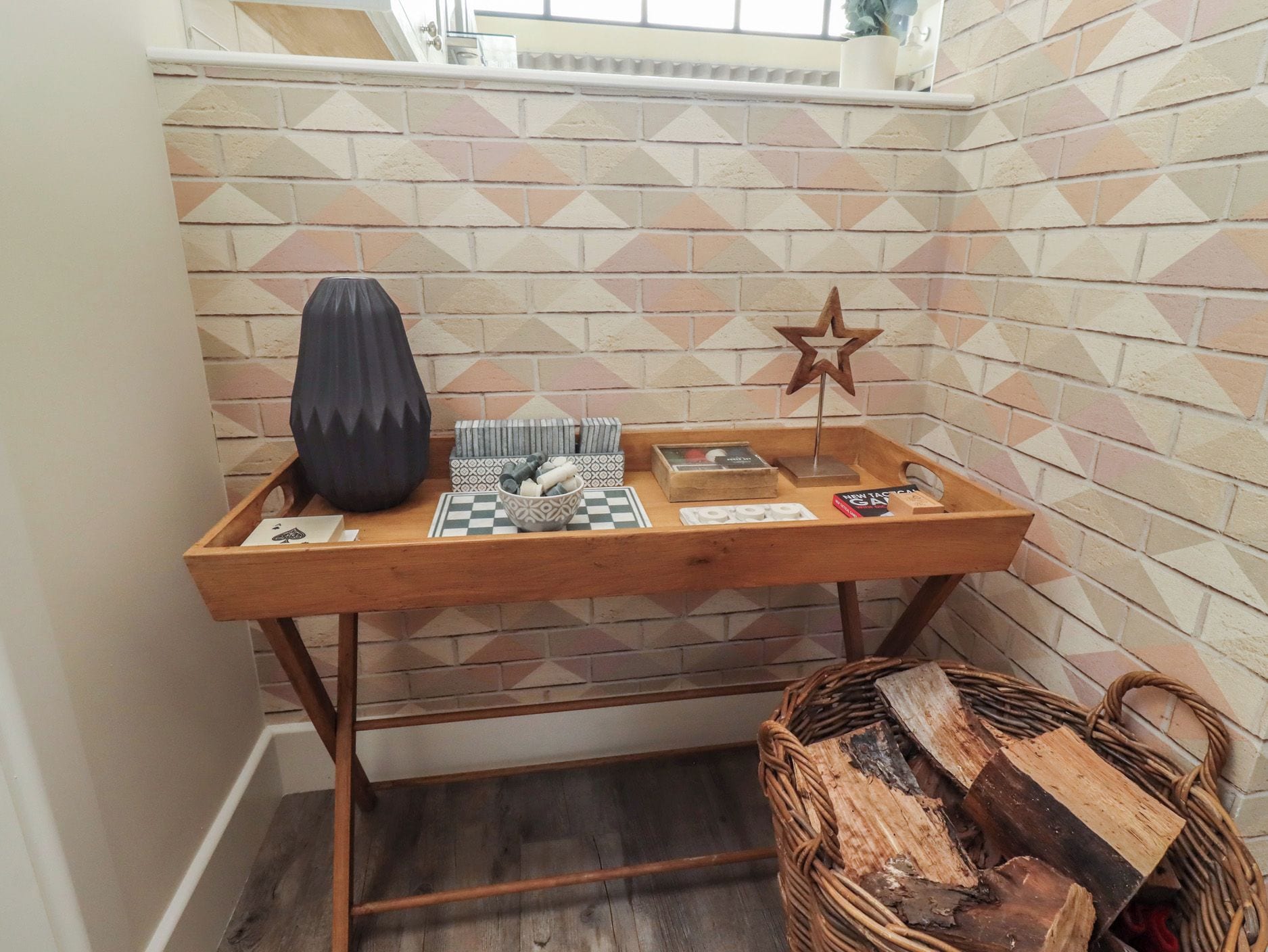 Uma mesa de madeira com um jogo de tabuleiro, uma decoração em forma de estrela e um vaso.