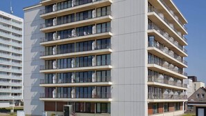 A multi-story hotel with balconies, a brick pathway, and a clear sky. - The "Kaiserhof 1" vacation rental. (Norderney)