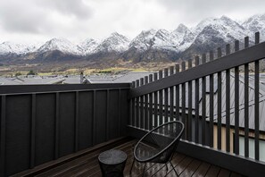 A balcony with a view of snow-capped mountains, a chair, and a small table. - Simply Remarkables View in Hanleys |3 bed home (Jack's Point)