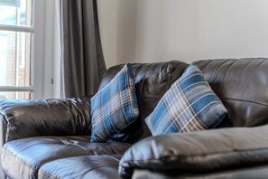 A leather sofa with two plaid cushions. - 5 Bed family house with free parking (Buckinghamshire)