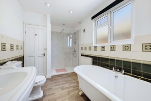 Ein Badezimmer mit Badewanne, Toilette und Duschbereich.