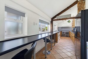 A kitchen with a long counter, a stove, and a sign that says 'this is no place like home.' - 5 Bed family house with free parking (Buckinghamshire)