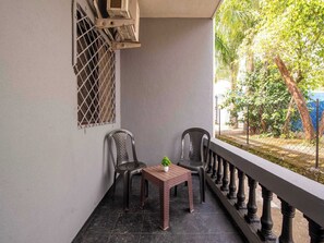 A balcony with two chairs, a small table, and a potted plant. - Palette Mountain Mist 2BHK Jacuzzi (Mawal)