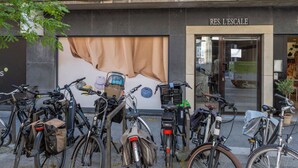 Rakennuksessa on myymälätila, jonka nimikyltissä lukee ’RES. L’ESCALLE’, ja sen ulkopuolella on rivi polkupyöriä.