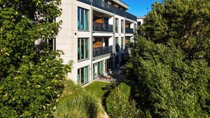 Ein modernes, mehrstöckiges Gebäude mit großen Fenstern und einem Balkon.