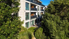 Ein modernes, mehrstöckiges Gebäude mit großen Fenstern und einem Balkon.