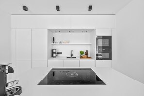 A modern kitchen with a built-in stove, a coffee maker, and a microwave. - Arrival amid the sea, light, and open landscape (List auf Sylt)