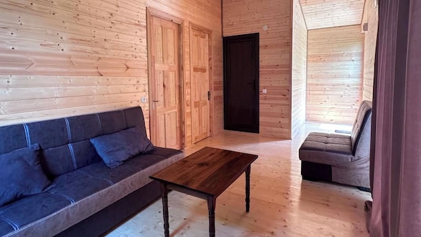 A wooden interior with a sofa, a coffee table, and a bench.