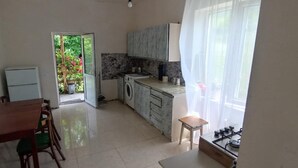 A compact kitchen with a dining area, a washing machine, and a small table.