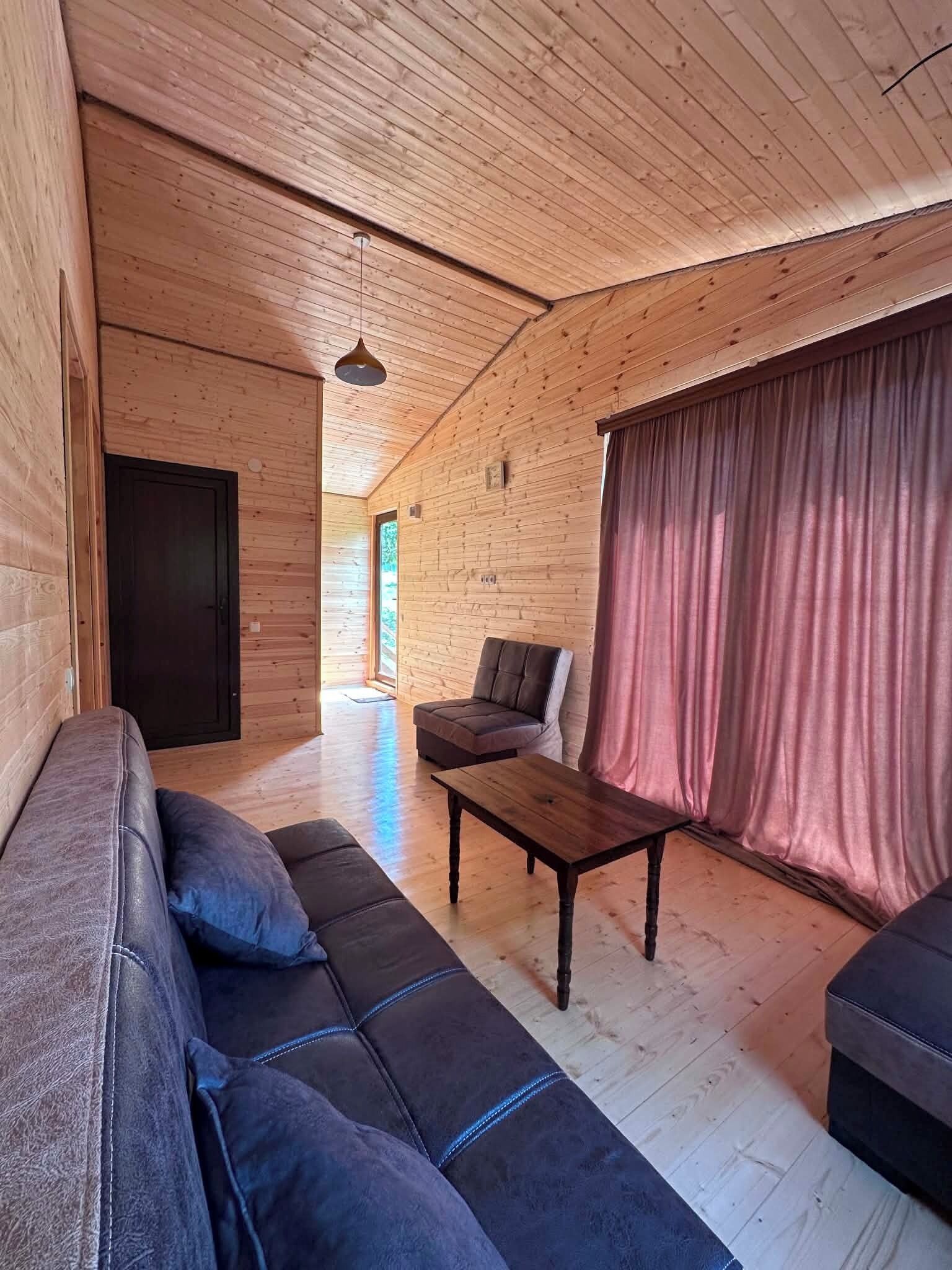 Et træinteriør med en sofa, et bord og en stol.