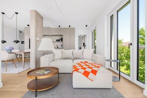 A modern living room with a sofa, a coffee table, and a dining area with chairs and a table. - Arrival amid the sea, light, and open landscape (List auf Sylt)