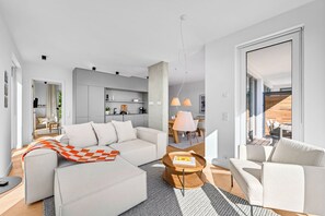 Una sala moderna con sofá, mesa de centro y comedor.