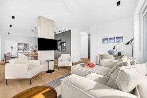 Ein modernes Wohnzimmer mit einer Couch, einem Couchtisch und einem Fernseher.