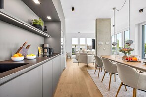 Eine moderne Küche mit Einbauofen, Kaffeemaschine und einer Pflanze auf der Arbeitsfläche.