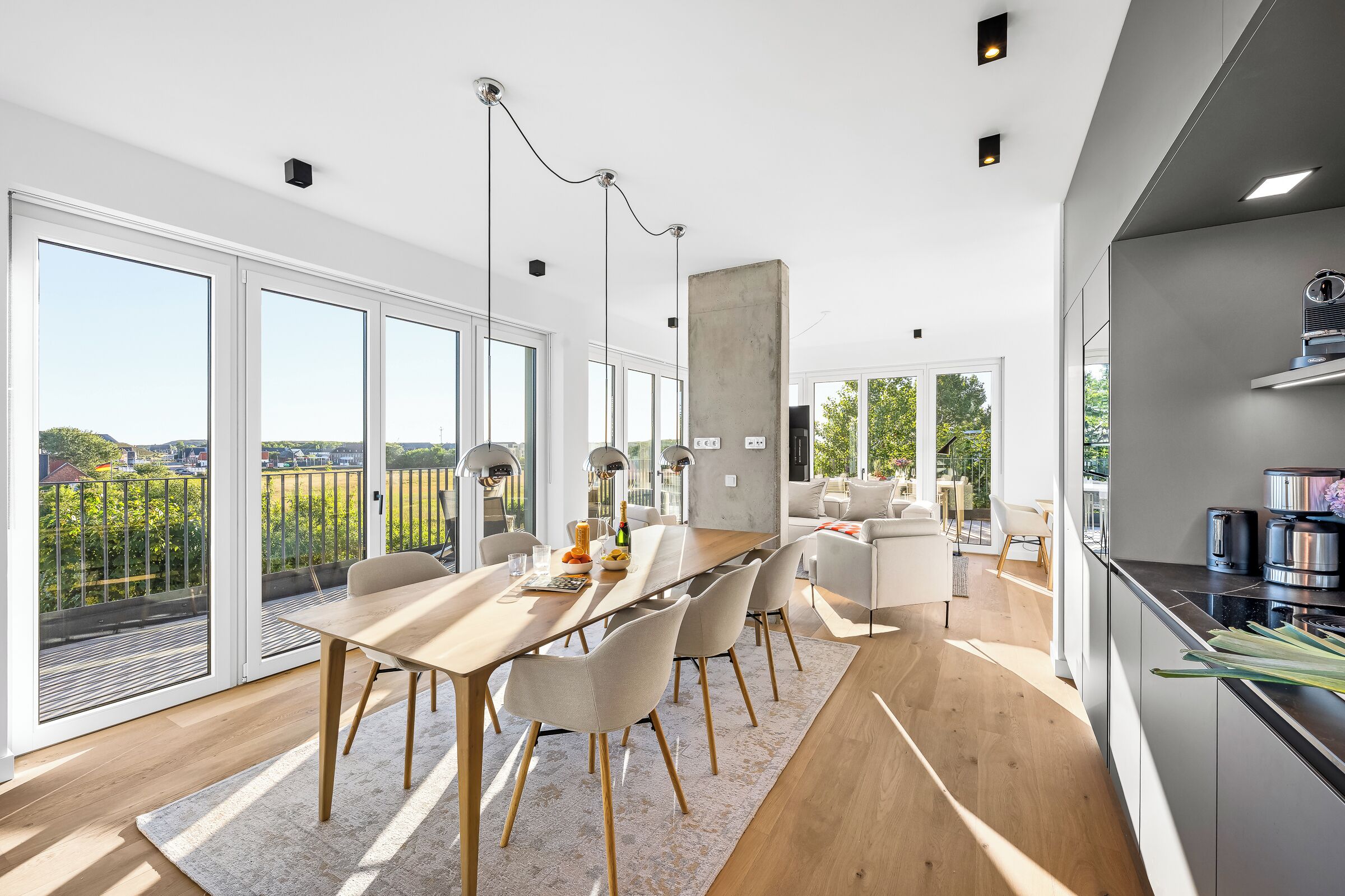 Eine moderne Küche mit Einbauofen und einem Essbereich mit langem Tisch und Stühlen.