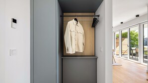 Et moderne interiør med et knagered, en vægmonteret lampe og udsigt gennem store vinduer.