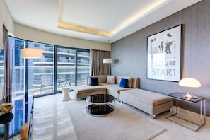 Ein modernes Wohnzimmer mit Sofa, Couchtisch und großem Fenster mit Blick auf die Stadt.