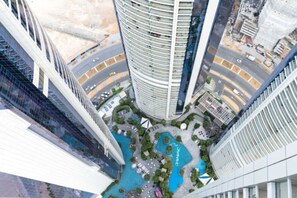 Ein Hochhaus mit einem kreisförmigen Pool, umgeben von Grünflächen und einer Straße.