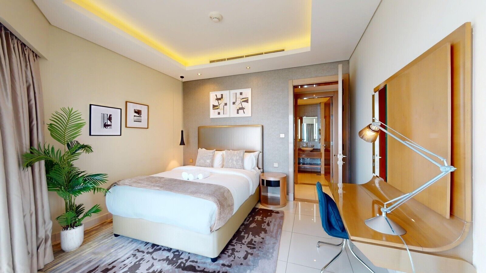 Een moderne hotelkamer met een groot bed, nachtkastje, bureau en stoel.