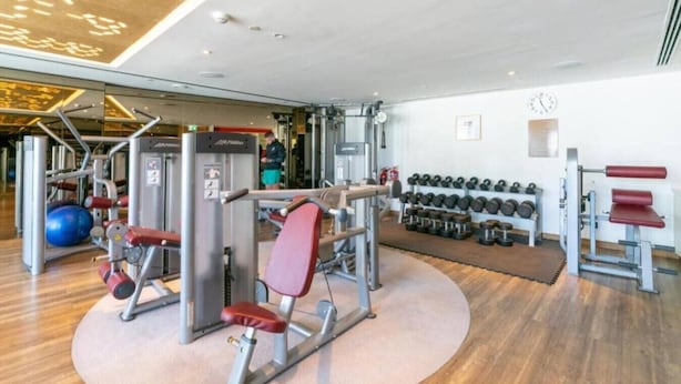 A gym with various exercise equipment, including a bench press, dumbbells, and a medicine ball. - Spacious 3 Bed with Burj Khalifa View l Pool & Gym (Business Bay)