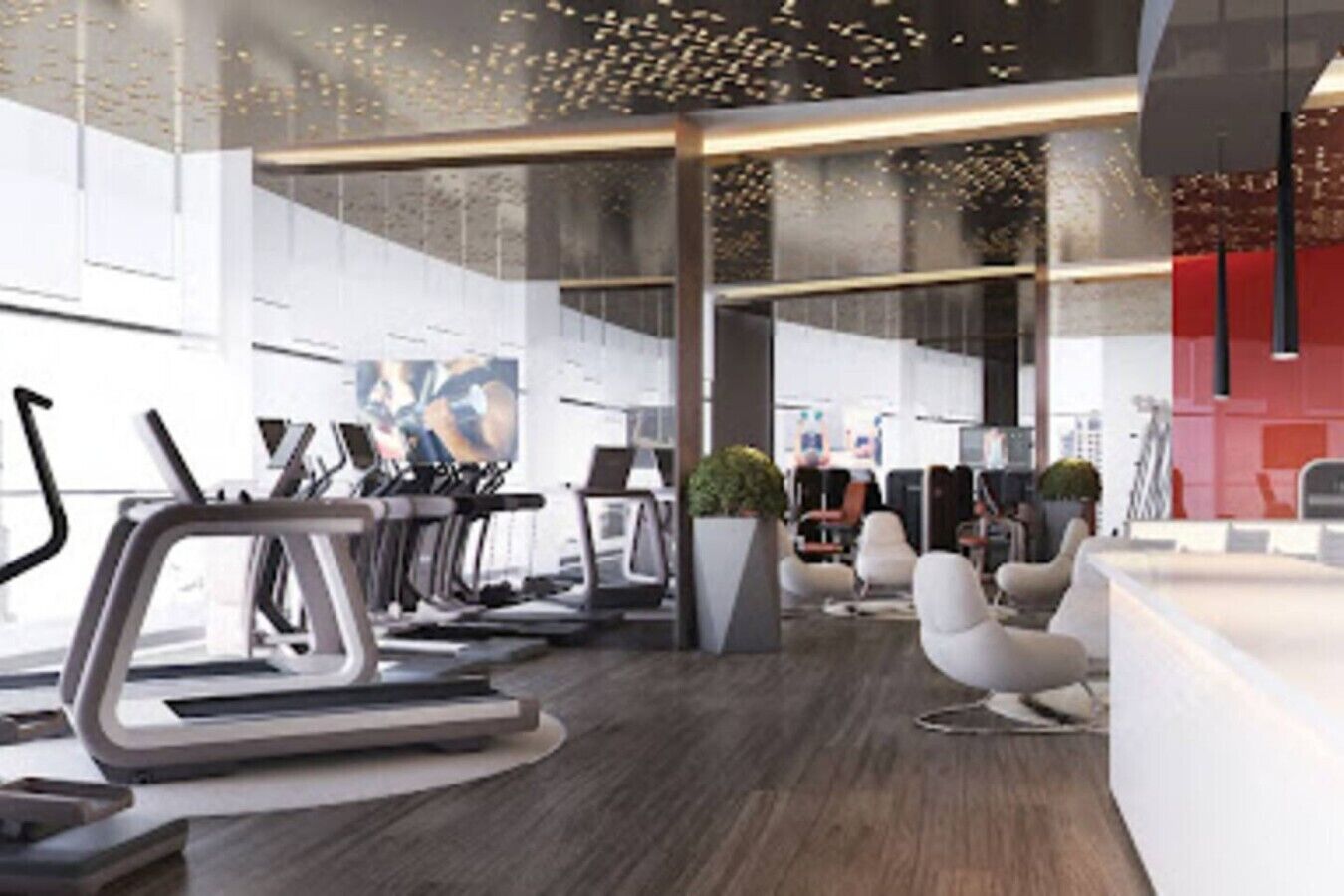 A modern gym with treadmills, stationary bikes, and a reception area with seating.