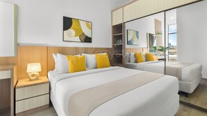 A modern hotel room with a large bed, bedside tables, a mirror, and a wall-mounted artwork. - Kaeva by Kozystay - Sudirman (Central Jakarta)