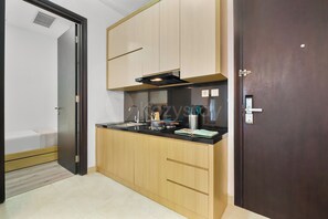 Eine moderne Küche mit Holzausstattung, einer schwarzen Arbeitsplatte und einem eingebauten Backofen.