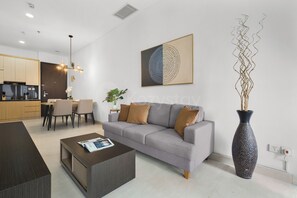 Un salon moderne avec un canapé gris, une table basse et un grand tableau abstrait.