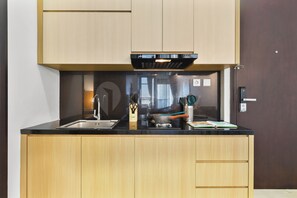 Eine moderne Küche mit schwarzer Arbeitsplatte, Holzschränken und einem eingebauten Ofen.